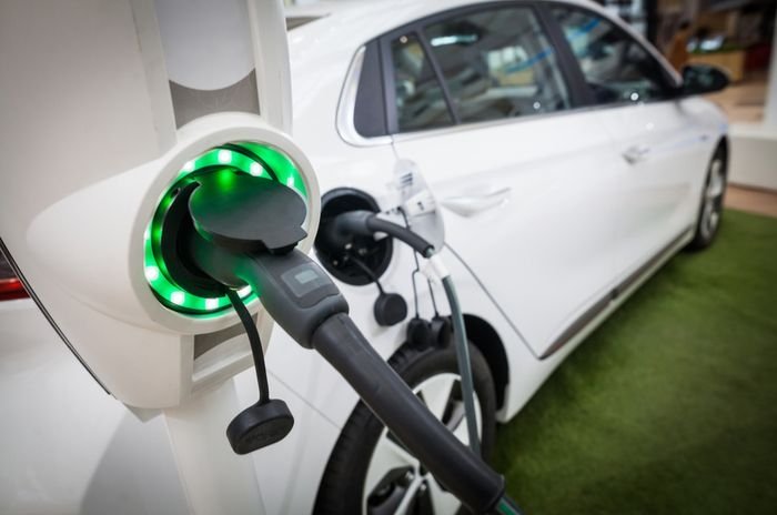 Close up view of white electric vehicle plugged into EV charger